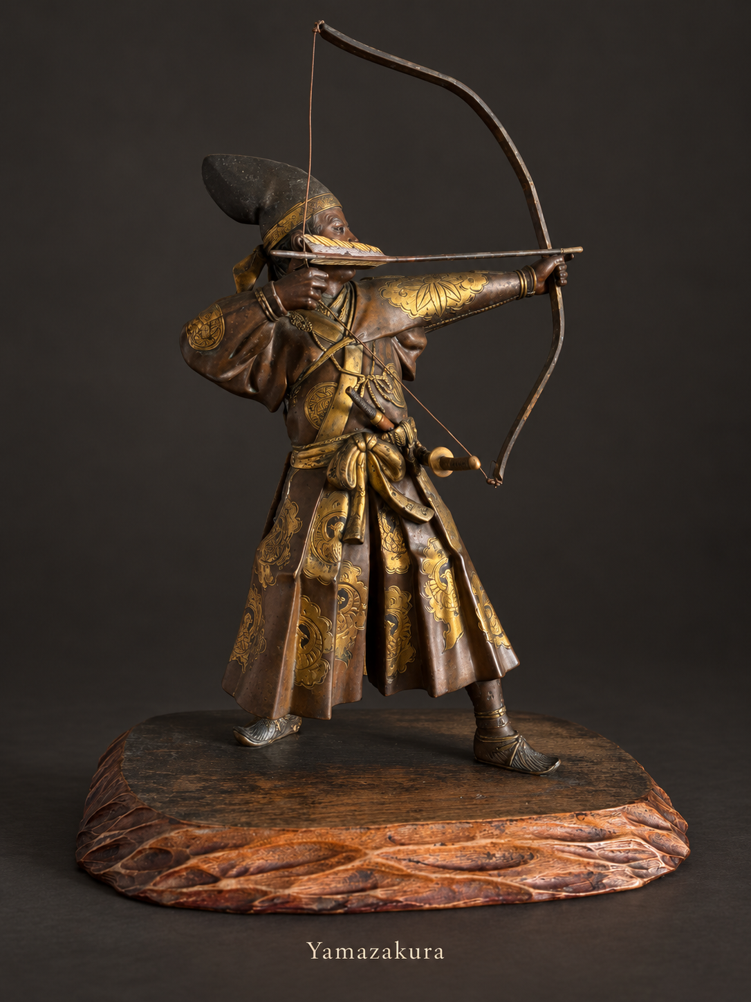 Japanese bronze archer with gilt decoration on carved wooden stand; Yamazakura styled presentation
